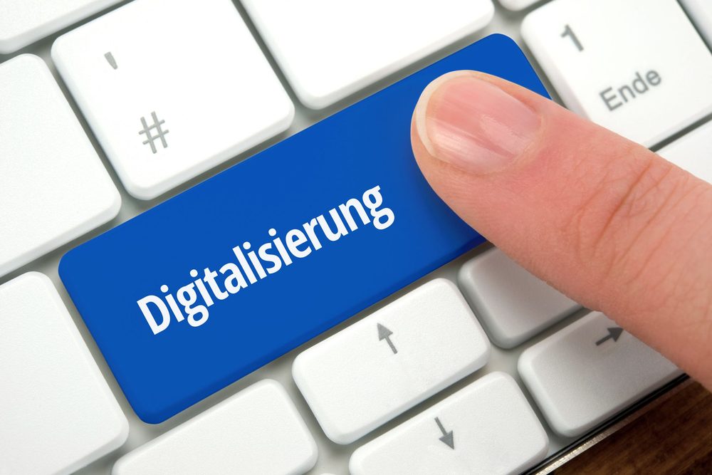 Finger drückt eine blaue Tastaturtaste mit der Aufschrift Digitalisierung